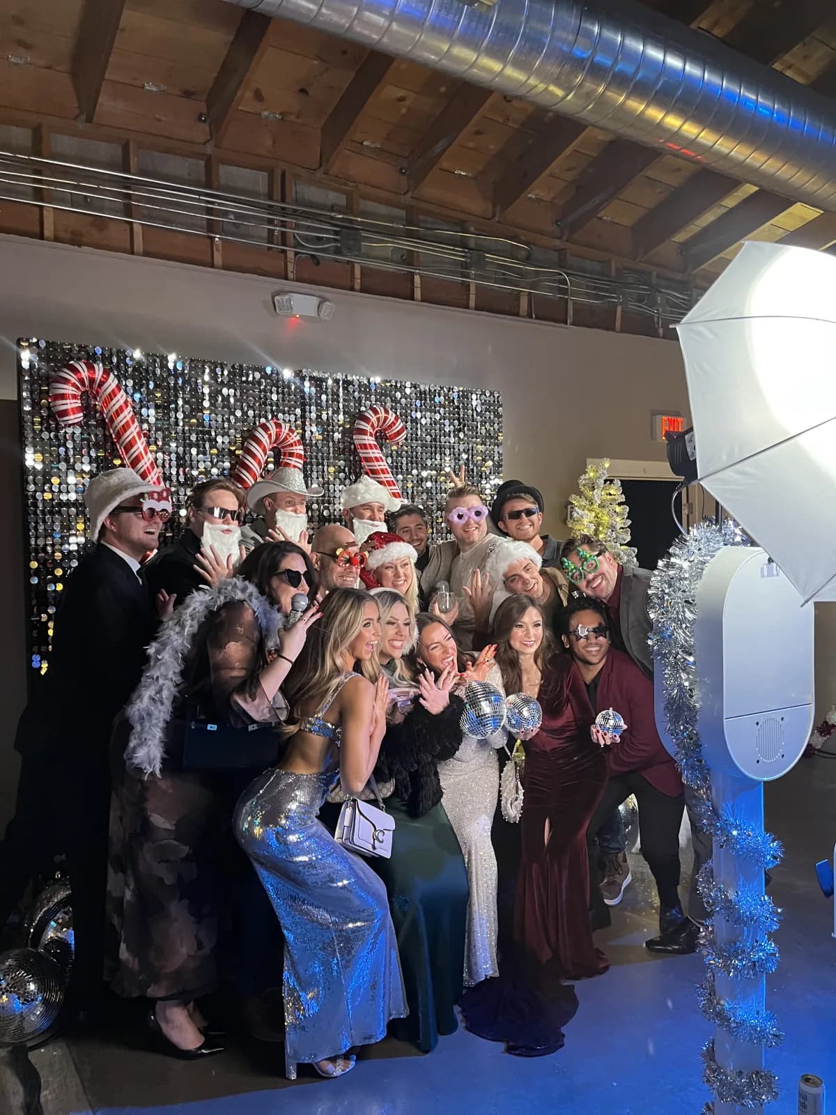 Holiday party guests posing beside the Honey Photobooth