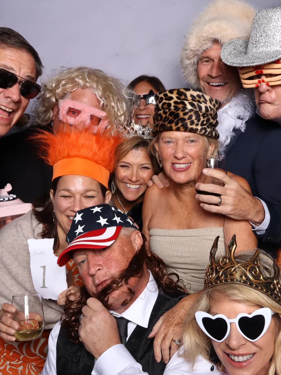 Celebration guests wearing costumes and photo booth props