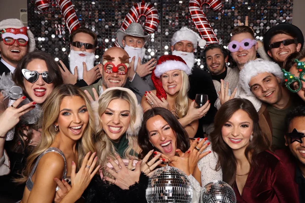 Holiday party guests posing together with festive props