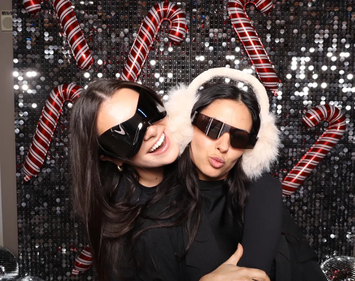 Two guests posing at a holiday photo booth