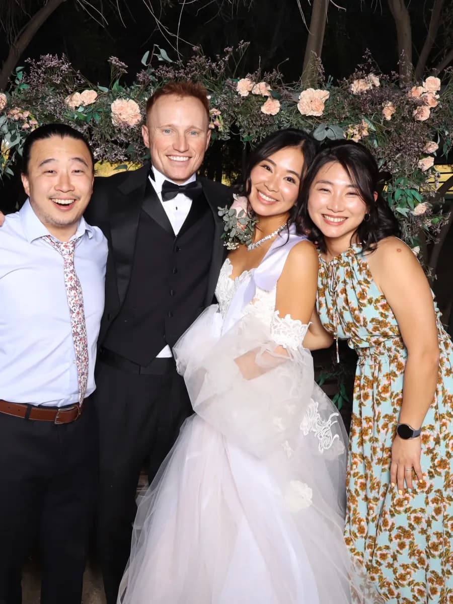 Wedding party posing in front of a floral backdrop